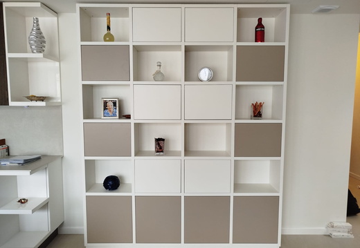 Libreria laccata bianca, con antine in luce  laccate beige, suddivisa in moduli sia aperti che chiusi.