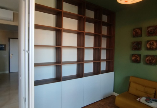 Libreria in noce con ante in nobilitato bianco nella parte inferiore 