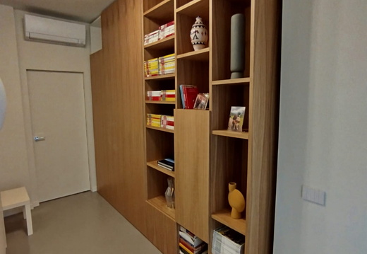 Armadio in nobilitato bianco con ante in rovere e libreria in rovere.