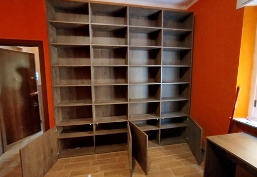 Libreria in noce scuro con antine nella parte inferiore